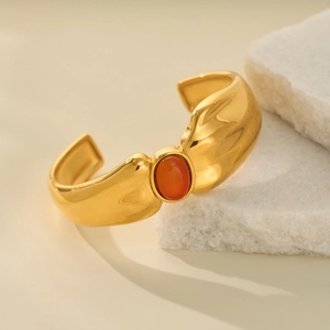 Macro detail of 18k gold plated chic cuff bracelet featuring a central orange gemstone