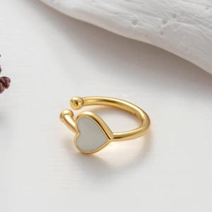 Detail of a gold heart-shaped ring with white filling and open adjustable band design