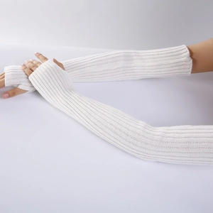 Close-up of white knitted arm warmer sleeves with thumb holes on model's arm