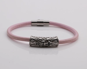 Detail showing pink braided leather bracelet with silver magnetic cross clasp
