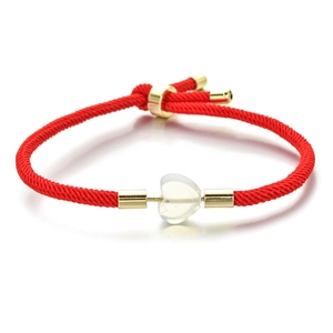 Adjustable red woven cord bracelet with gold accents and heart-shaped stone charm