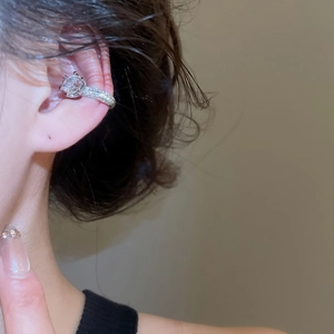 Close-up of silver ear cuff with zircon stones on a model's ear showing elegant details
