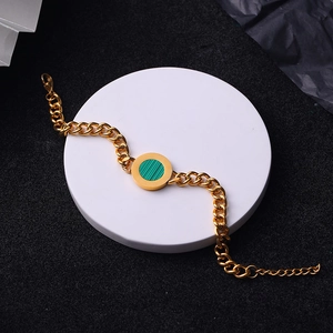Detail of gold Cuban chain bracelet featuring a round green malachite stone insert