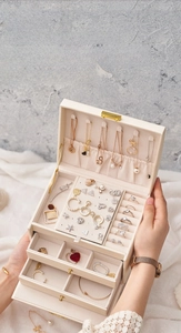 Detail of a 3-layer jewelry box with necklace hooks and velvet earring storage compartments