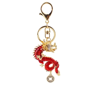 Golden dragon keychain with red crystal body and small coin charm on white background