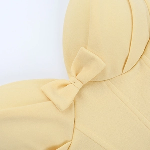 Detailed macro shot of the elegant light yellow bow tie decoration on the halter neck dress