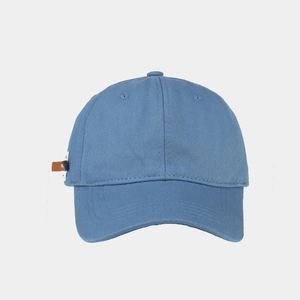 Close-up of blue cotton twill baseball cap showing side leather patch and stitching