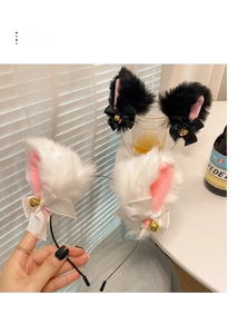 Detail of plush cat ear headband featuring satin bows and golden metal bells accessory