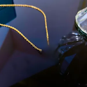 Macro detail of double ring gold necklace with Roman numerals and white zircon inlay