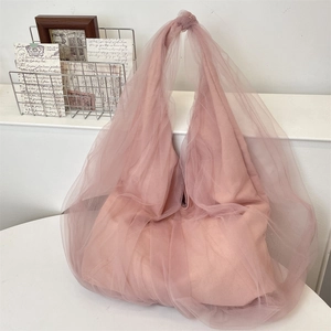 Vue détaillée du cabas en résille rose avec superposition de tulle léger et anse nouée