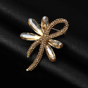 Detailed close-up of golden flower brooch with rhinestones and crystal teardrop petals