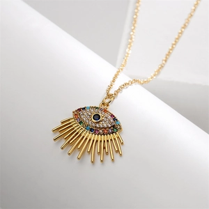 Detailed close-up of golden evil eye necklace with blue zircon and sunburst spikes
