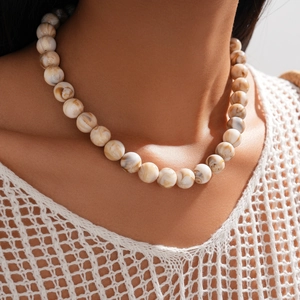 Close-up of marble-patterned beige and brown acrylic beads on a fashion necklace