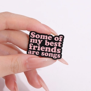 Black enamel badge with pink text Some of my best friends are songs held in hand