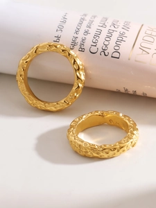 Macro detail of golden molten lava texture and hammered finish on stainless steel rings