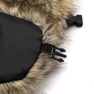 Detail of winter trapper hat showing black leather texture and brown faux fur with buckle