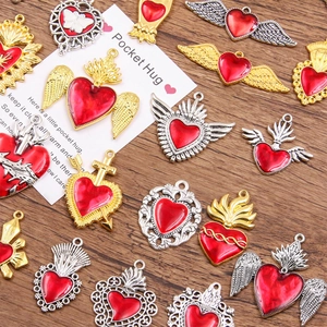 Close-up of red enamel heart charms with Pocket Hug card on a natural wood surface
