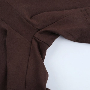 Detailed close-up of tight stitching and fabric texture on a dark brown jumpsuit