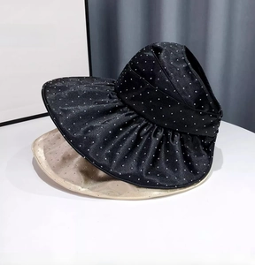 Detail of black and champagne sun hats with rhinestone dots and wavy wide brims