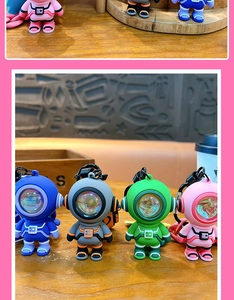 Detailed close-up of colorful astronaut keychains with LED lights on a wooden table