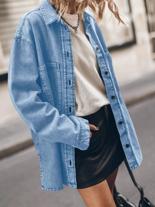 Close-up of oversized light blue denim shirt with large pockets and button details
