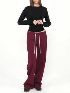 Women's low-waist burgundy drawstring sweatpants styled with a black knit top