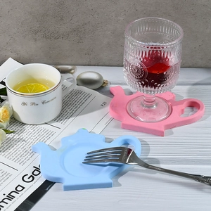 Detail of teapot-shaped silicone coasters in pink and blue for heat-resistant table protection