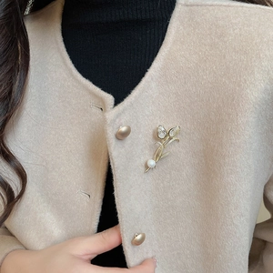 Close-up of elegant 14K gold plated tulip brooch with sparkling crystals and pearl detail