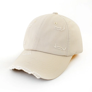 Detail showing vintage distressed holes and worn texture on a beige cotton baseball cap