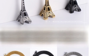Detailed view of Eiffel Tower pendants in gold, silver, and black on braided steel chains
