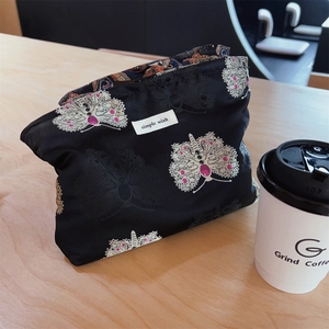 Detailed macro of vintage jacquard fabric clutch with elegant butterfly pattern