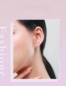 Close-up of S925 sterling silver geometric chain earrings worn on a female ear lobe