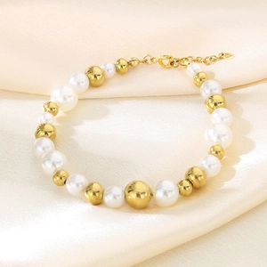 Détail d'un élégant bracelet de perles d'eau douce avec perles dorées sur soie champagne