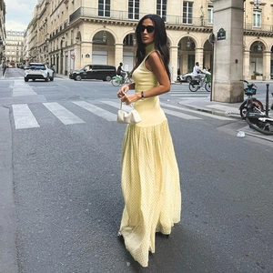 Dettaglio di un abito lungo giallo chiaro con corpetto in maglia e gonna in rete fluida