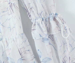 Vue détaillée de la robe en mousseline fleurie avec poignets à volants et lien à nouer
