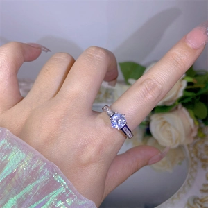 Detail of six-prong silver ring with large round zircon and side stone accents on hand