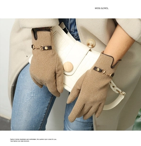 Close-up of warm winter gloves with elegant metal buckle and brown leather trim detailing