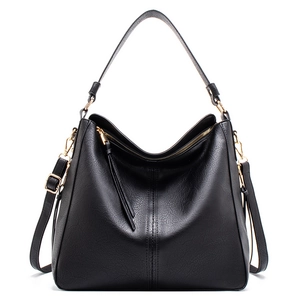 Detailed view of black tote bag with lychee texture leather and gold metal hardware