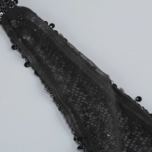 Close-up of black mesh fabric with sparkling sequins on a sexy evening party dress