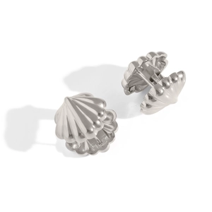Detailed view of silver shell-shaped hoop earrings with striped geometric texture
