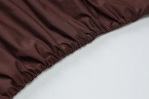 Detailed macro shot of brown ruched fabric with elastic texture and sharp fiber weave