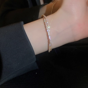 Close-up of golden crossover zircon bracelet with shimmering pavé crystals on wrist