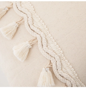 Detailed close-up of beige woven texture with handmade fringe and bohemian tassels