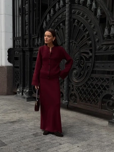 Detail of burgundy knit cardigan and skirt set featuring buttons and elegant ribbed texture