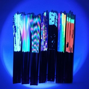 Detailed collection of fluorescent UV-reactive hand fans with vibrant diverse patterns