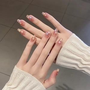 Close-up of elegant long square press-on nails with floral patterns on hands
