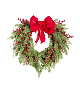 Close-up of artificial pine wreath with red berries, pine cones and a large red bow