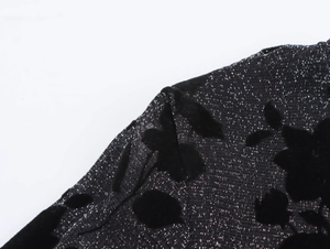 Macro shot of elegant black velvet floral jacquard fabric with silver glitter knitting