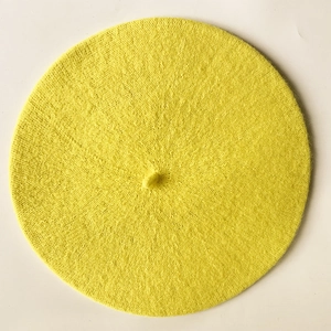 Detailed top view showing the fine knit texture and stem of a bright yellow beret hat