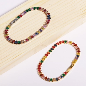 Detail of 18K gold plated rainbow tennis bracelet with colorful zircon stones on wood